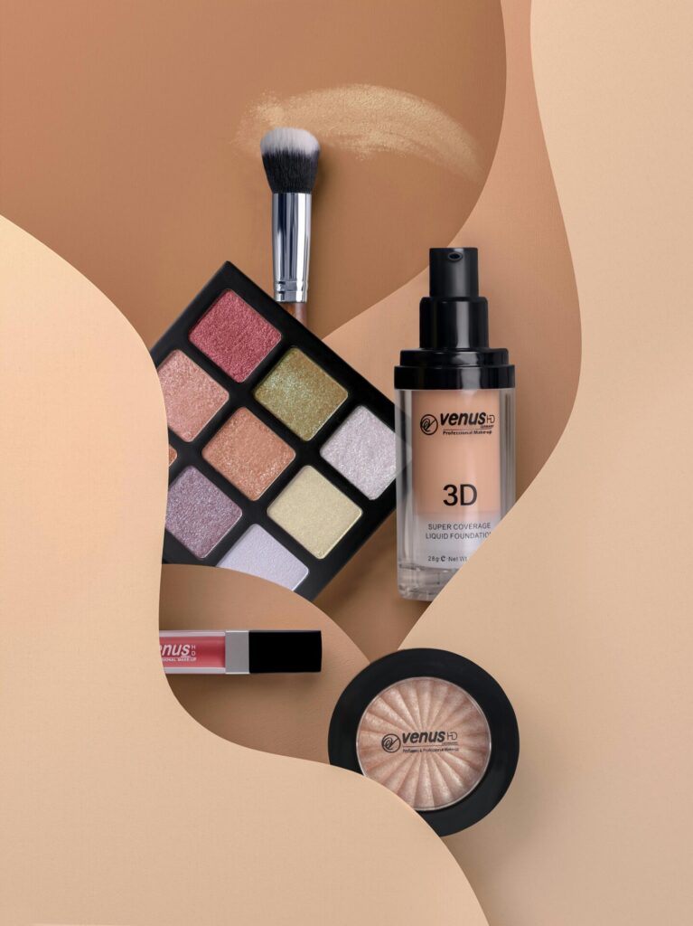Flat lay of cosmetics including eyeshadow, lipstick, and blush with neutral tones.